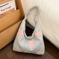 Detail of light blue hobo bag featuring pink plush stars and ruffled cloud shoulder strap - Light Blue
