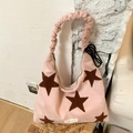 Detail of pink plush star handbag with scrunchie strap and white woven brand label - Pink