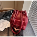 Detailansicht der weinroten Beuteltasche mit mattem Finish und Webnaht auf modernem Schreibtisch - Burgunderrot