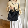 Versatile black denim tote bag with white contrast stitching and adjustable shoulder strap - Black