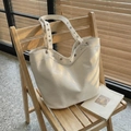 Cream large capacity tote bag with metal eyelet details on a wooden chair - Off-white
