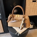 Sac bowling en toile marron avec anses en cuir et breloques de mode sur un tabouret - Avec Pendentif / Marron