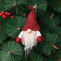 Gnomo di Natale con cappello di feltro rosso e maniche a righe su ramo di pino - Rosso