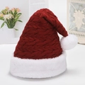 Thick knit red Christmas hat with white pompom and cable texture on a cozy background - Red