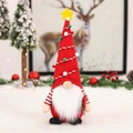 Gnomo di Natale con cappello rosso a punta e barba bianca su un tavolo festivo - Albero Rosso