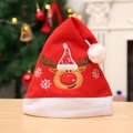 Bonnet de Noël rouge festif avec broderie de renne blanche posé sur une table en bois - Style Renne