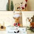 Detailansicht der Leinen-Weihnachtstüte mit 3D-Plüschrentier und kariertem Schal - Beige