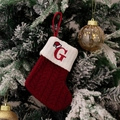 Detail of red cable-knit Christmas stocking with embroidered letter G on a snowy tree - Style G (Red Knit Embroidered G)