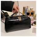 Close-up of black crocodile pattern travel makeup bag with gold hardware and zippers - Black