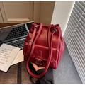 Vue détaillée d'un sac seau rouge vintage avec coutures tressées et cordon de serrage - Bordeaux