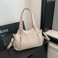 Detail view of lychee-patterned PU leather tote with rivets and adjustable shoulder strap - Off White