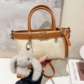 Bolso cubo de paja tejida en crema y marrón con un lindo colgante de conejo de peluche - Blanco Roto