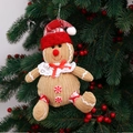Detail eines Plüsch-Lebkuchenmanns mit roter Weihnachtsmütze an einem Weihnachtsbaum - Bein Stil Männlich