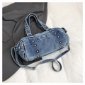 Detailed macro view of washed denim fabric texture and silver rivets on bowling bag - Light Blue