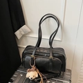 Detail of black faux leather shoulder bag with dual zipper compartments and puppy charm - Black With Pendant