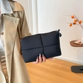 Chic black quilted puffer clutch bag with minimalist soft padding and zipper closure - Black