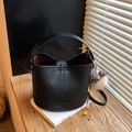 Black lychee leather bucket bag with leopard bow and plush charm on white book - With Pendant / Black