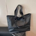 Minimalist black nylon tote bag with wide fabric shoulder strap and modern matte finish - Black