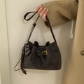 Retro dark brown suede bucket bag with gold buckle and tassel detail carried by model - Coffee