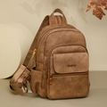 Detail eines braunen Kunstleder-Rucksacks mit Metall-Logo und Multi-Taschen-Design - Gelbbraun