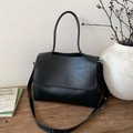 Dettaglio borsa shopper nera in pelle testurizzata su un tavolo di legno antico - Nero senza Ciondolo