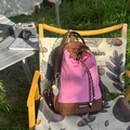 Detalle de una mochila de exterior de cuadros rosas en una silla de camping al aire libre - Con Colgante / Marrón y Rosa Rojo