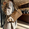 Vintage brown matte shoulder bag with a cute white rabbit pendant in a cozy cafe - Brown with Pendant