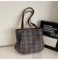 Close-up of blue plaid tweed tote bag featuring an oval metal logo and textured fabric - Blue