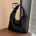 Dettaglio della borsa tote in nylon nero con trama pieghettata e tracolla ampia fissa - Nero