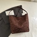 Braune Tragetasche mit Leopardenmuster und Wildlederstruktur auf grauem Blazer - Leopardenbraun