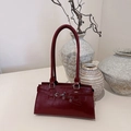 Vintage burgundy leather shoulder bag with silver hardware in minimalist setting - Burgundy