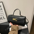 Elegante zwarte geweven handtas met een gouden draaislot en een chique bovenste handgreep - Zwart
