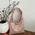 Sac hobo punk rose avec rivets argentés posé sur une surface en bois minimaliste - Rose
