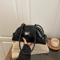Minimalist black patent leather half moon shoulder bag with glossy finish and metal tag - Black