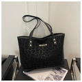Detail der schwarzen Tote-Bag mit Leopardenmuster, Matten-Textur und Gold-Plakette - Schwarz