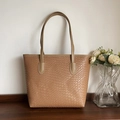 Detalle de la textura tejida y las asas de cuero del bolso tote grande marrón caramelo - Caqui