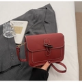 Dettaglio della borsa a tracolla in pelle bordeaux con cuciture bianche e chiusura - Borgogna