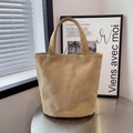 Borsa tote minimalista in pelle scamosciata beige con ampi manici in uno studio d'arte - Beige