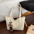 Minimalist beige leather tote bag with brown rabbit charm on wooden floor - With Pendant / White