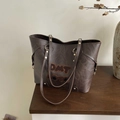 Detailaufnahme der braunen Vintage-Einkaufstasche mit Plissee-Leder und Buchstaben-Patches - Braun