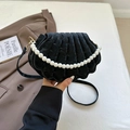 Detail of black shell-shaped bag with velvet texture and elegant white pearl handle - Black