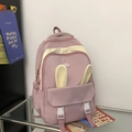 Detail van roze en witte rugzak met schattige konijnenoren en mode-rubberlabel - Roze
