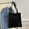 Elegant black velvet tote bag with textured leaf pattern and gold snap closure - Black