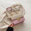 Pink crossbody bag featuring straw weave flap and golden chain strap detail - Pink