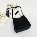 Sac seau noir minimaliste avec chaîne dorée et bandoulière en cuir réglable - Noir