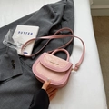Borsa a sella rosa con barra metallica dorata e tracolla regolabile su blazer grigio - Rosa