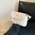 Close-up of white crossbody bag with a metallic bow ornament and decorative knotted strap - White