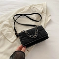Bolso bandolera acolchado negro con elegante detalle de cadena sobre fondo blanco - Negro