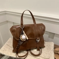Rückansicht des braunen Lederrucksacks mit Metallschnallen und Baseball-Anhänger - Mit Anhänger / Braun