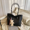 Elegant black leather tote bag for women with bear charm and chic woven strap accessory - With Pendant / Black